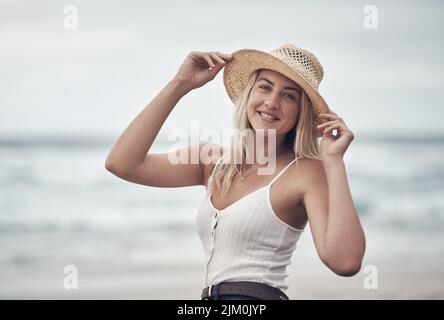 Non potete stare al sole senza il cappello, una bella giovane donna che trascorre la giornata in spiaggia. Foto Stock