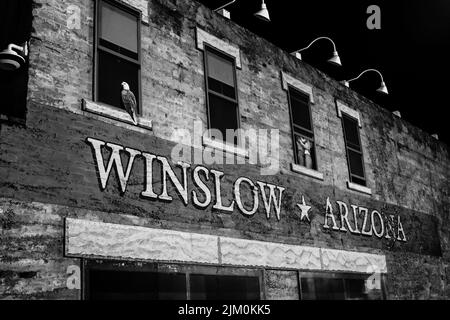 Un'immagine in scala di grigi dell'edificio vicino al Corner Park durante la notte nella città di Winslow, Arizona, USA Foto Stock