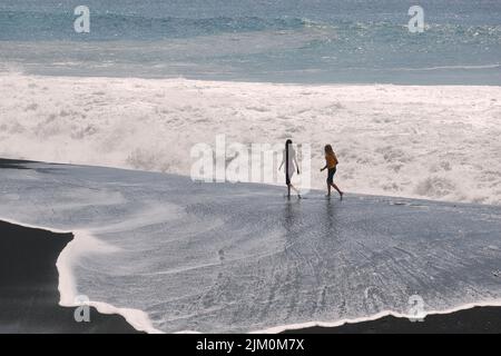 I turisti che si godono una passeggiata sulla spiaggia Foto Stock