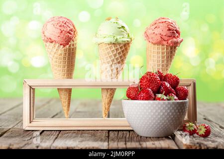 Vari gelati in coni waffle e ciotola con fragola Foto Stock