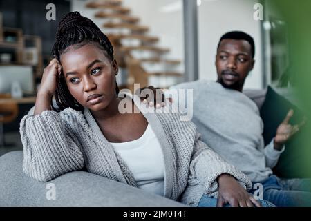 Chiudere il gap inizia con uscire. Una giovane coppia che si avvicina a sua moglie dopo aver avuto un argomento sul divano a casa. Foto Stock