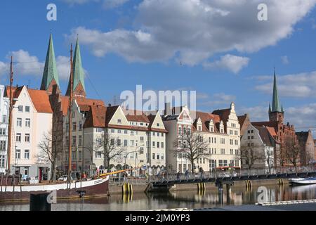 Lubeck, Germania, 11 aprile 2022: Città vecchia di Lubeck sul fiume Trave vicino al Mar Baltico, barche a vela storiche, case di città e torri di chiesa, Travel de Foto Stock