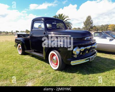 Chascomus, Argentina - Apr 09, 2022: Vecchio camion nero di servizio pick-up Ford F 1 1950s in campagna. Erba naturale e alberi. Mostra di auto classiche. Copys Foto Stock