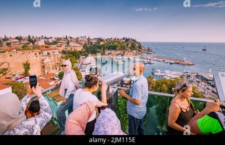 21 giugno 2022, Antalya, Turchia: Folle di turisti al punto di osservazione utilizzando binocoli e guardando al porto della città vecchia con yacht e. Foto Stock