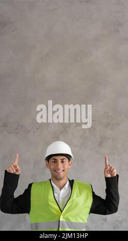 Bell'uomo arabo che indossa casco di sicurezza e giacca riflettente sorridendo con un'idea puntando le dita verso l'alto con il volto felice, numero due, banner Foto Stock