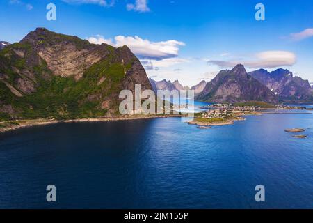 Villaggio di pescatori Reine circondato da alte montagne e fiordi sulle isole Lofoten Foto Stock