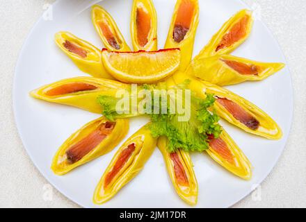 Pancake ripieni di pesce rosso e tagliati a pezzi. Piatto con pancake da vicino. Foto Stock