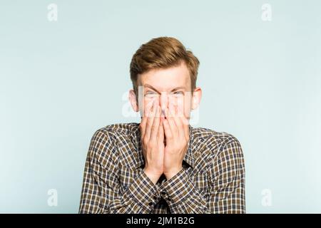 felice felice eccitato gioioso uomo che copre l'emozione della bocca Foto Stock