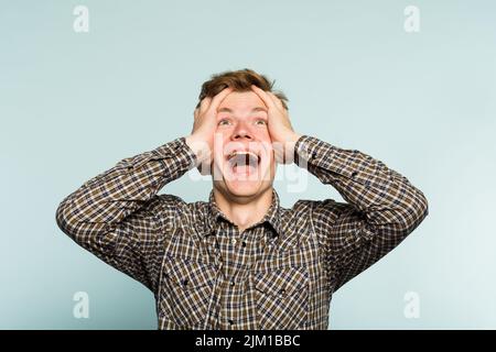overjoyed uomo felice eccitato che si aggrappa testa emozione Foto Stock