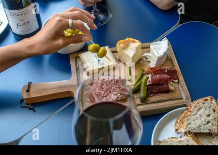 Vino rosso, salumi e formaggi, vino rosso, spuntini e mani di gente Foto Stock