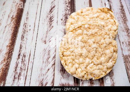 Un cracker di riso rotondo su un rustico tavolo di legno. Spazio di copia. Cibo sano e naturale. Cibo vegano. Vista alta Foto Stock