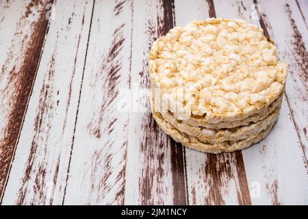 Un cracker di riso rotondo su un rustico tavolo di legno. Spazio di copia. Cibo sano e naturale. Cibo vegano. Vista alta Foto Stock