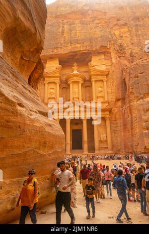 La folla guarda il primo sguardo del palazzo del Tesoro da al Siq in Petra Jordan. Foto Stock