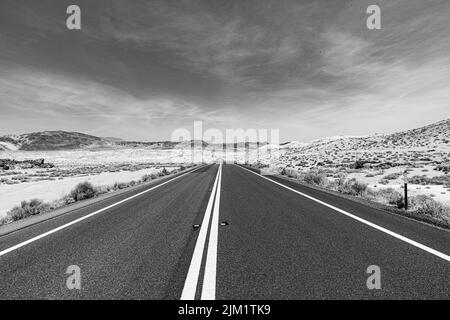 Strada nel mezzo del nulla passando il deserto negli Stati Uniti Foto Stock