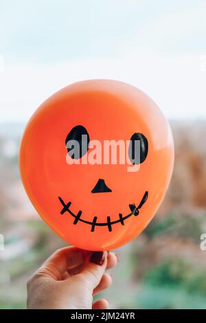 Le prese dipinte si affacciano sulle bollature. Preparazione di palle bianche e arancioni per la festa di Halloween. Attività domestiche di Halloween. Giocattoli fatti a mano Foto Stock