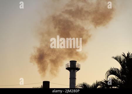 Goiania, Goiás, Brasile – 04 agosto 2022: Fumo che sale dai camini di una fabbrica. Inquinamento da fumo della fabbrica con il cielo sullo sfondo. Foto Stock