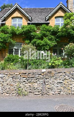 Un rubinetto d'acqua in disuso si trova presso il muro di una casa nel villaggio di Gloucestershire di Adlestrop. Foto Stock