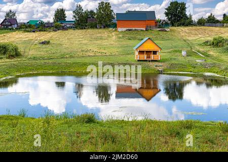 bagno in legno sulla riva di un piccolo stagno Foto Stock