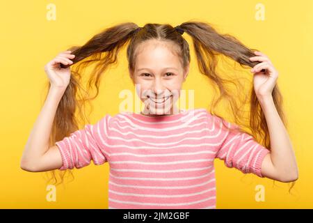 gioiosa ragazza maialino coda pelo bambino Foto Stock