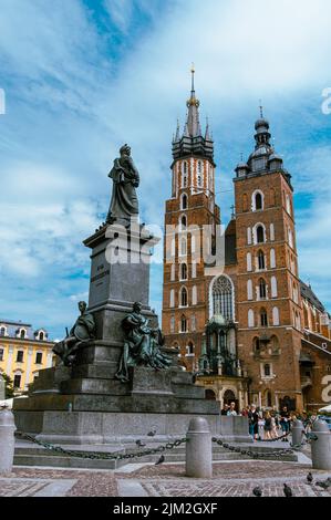 Cracovia, Maloplskie voivodship, Polonia; 1st agosto 2022: Chiesa di Mariaci con il monumento di Adam Mickiewicz sulla piazza principale della città Foto Stock