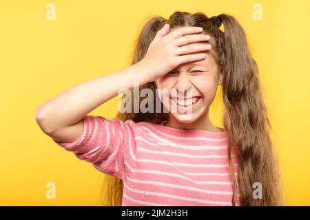 ashamed sorridente ragazza coprire fronte embarrass mano Foto Stock