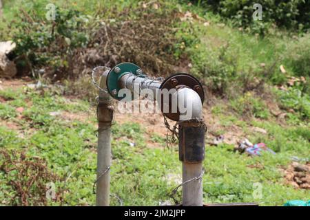 Vecchia pompa dell'acqua sommersa o sotterranea collegata con tubi metallici per trasportare l'acqua ai luoghi Foto Stock