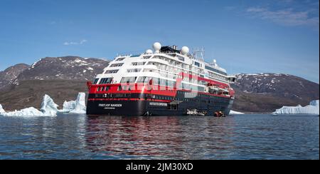 Primo piano della nave da crociera della spedizione MS Fridtjof Nansen di Hurtigruten in mezzo ad iceberg con zodiaci fuori carico a Disko Bay, Groenlandia il 18 luglio 2022 Foto Stock