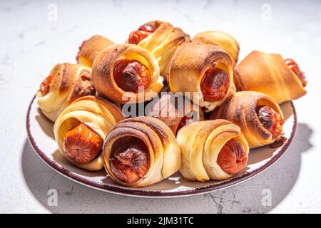 Cibo per feste Oktoberfest. Hot dog pretzel, panini con pasta sfoglia con salsiccia e pancetta, maiali tradizionali bavaresi tedeschi in coperta su Oktoberfest decorazione Foto Stock