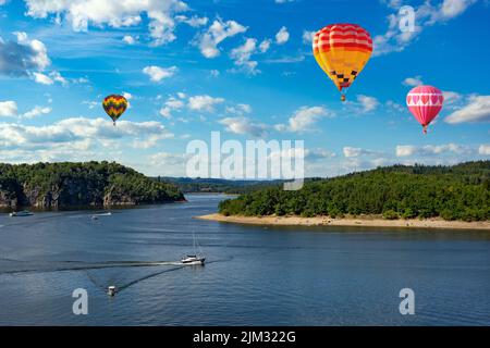 Mongolfiere nel cielo sopra il fiume Moldava vicino al castello di Orlik. Czechia Foto Stock