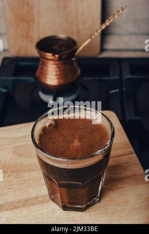 Bicchiere di caffè caldo preparato in Jezve di rame Foto Stock