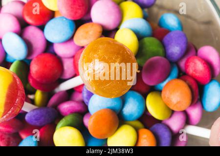 Primo piano di lecca con caramelle al cioccolato multicolore nel recipiente Foto Stock