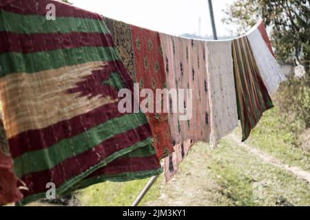 Coperte fatte a mano in un villaggio, impiccate in una corda per asciugare dopo il lavaggio Foto Stock