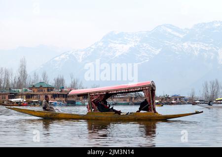 Ritratto di un marinaio indiano Kashmiri Shikara sul lago dal. Le mani potrebbero essere sfocate a causa del movimento. Foto Stock