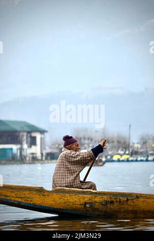 Ritratto di un marinaio indiano Kashmiri Shikara sul lago dal. Le mani potrebbero essere sfocate a causa del movimento. Foto Stock