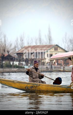 Ritratto di un marinaio indiano Kashmiri Shikara sul lago dal. Le mani potrebbero essere sfocate a causa del movimento. Foto Stock