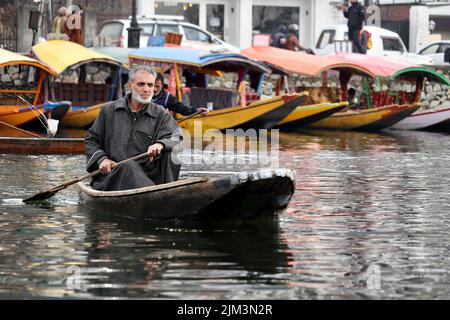 Ritratto di un marinaio indiano Kashmiri Shikara sul lago dal. Le mani potrebbero essere sfocate a causa del movimento. Foto Stock