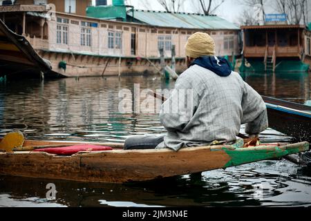 Ritratto di un marinaio indiano Kashmiri Shikara sul lago dal. Le mani potrebbero essere sfocate a causa del movimento. Foto Stock