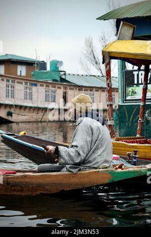 Ritratto di un marinaio indiano Kashmiri Shikara sul lago dal. Le mani potrebbero essere sfocate a causa del movimento. Foto Stock