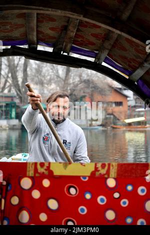 Ritratto di un marinaio indiano Kashmiri Shikara sul lago dal. Le mani potrebbero essere sfocate a causa del movimento. Foto Stock