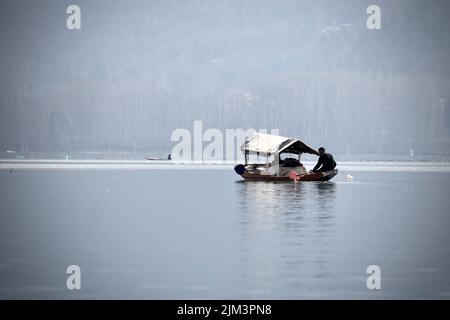 Ritratto di un marinaio indiano Kashmiri Shikara sul lago dal. Le mani potrebbero essere sfocate a causa del movimento. Foto Stock