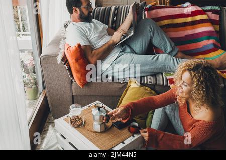 Sorridente coppia caucasica seduta a casa rilassante a colazione o caffè tempo Foto Stock