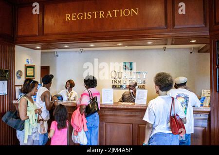 Hampton Virginia, Tidewater Area, Quality Inn & Suites hotel hotel hotel alloggio lobby reception prenotazione registrazione Black famiglie ospiti che effettuano il check in Foto Stock