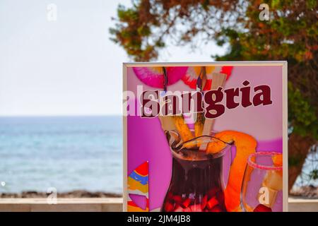 La foto mostra un cartello pubblicitario per la sangria a SA Coma, Maiorca, con il mare sullo sfondo Foto Stock