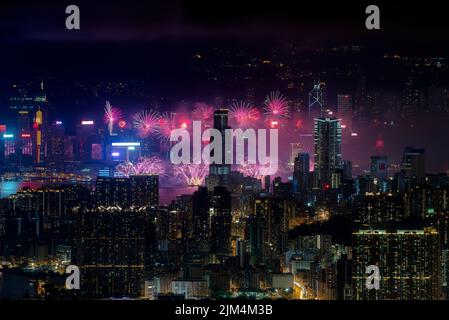Una vista ipnotica dei fuochi d'artificio sul Victoria Harbour a Hong Kong con moderni grattacieli di notte Foto Stock