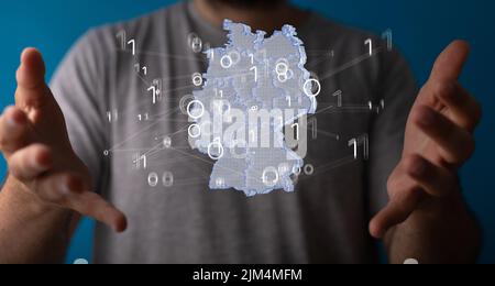 Un rendering 3D di una mappa tedesca che levita tra le mani di una persona Foto Stock