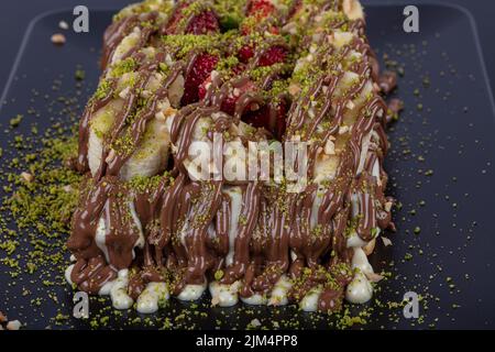 Waffle belgi decorati con salsa al cioccolato e frutta fresca isolata su sfondo nero. Foto Stock