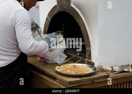 Mosca, Russia, 2022.07.09. Popolare parco ricreativo VDNKh Baking Central Asian nazionale torte, lo chef maschile fa il pane a forma di cuore. Foto Stock