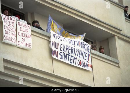 Bucarest, Romania, gennaio 1990. Persone che osservano e sostengono i manifestanti nel centro di Bucarest dal loro appartamento. Dopo la rivoluzione anticomunista del dicembre 1989, i disordini civili continuarono, poiché la maggior parte dei nuovi al potere erano gli ex funzionari comunisti. Foto Stock