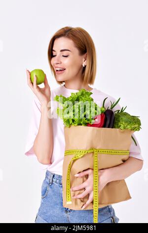 donna caucasica tenere sacchetto di carta con verdure Foto Stock