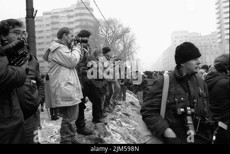 Bucarest, Romania, gennaio 1990. Fotografi stampa che si occupano dei raduni in Piazza dell'Università dopo la Rivoluzione rumena del 1989. La gente si riunirebbe ogni giorno per protestare contro i funzionari ex comunisti che hanno preso il potere dopo la Rivoluzione. Foto Stock